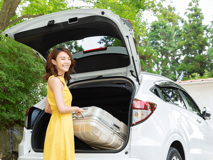 Traveller packing suitcase into car
