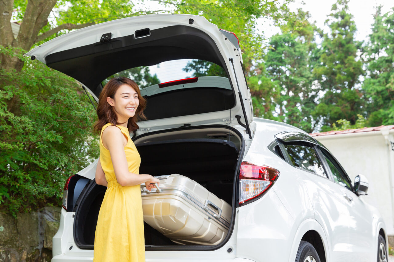 japanese woman loading luggage in a rental car